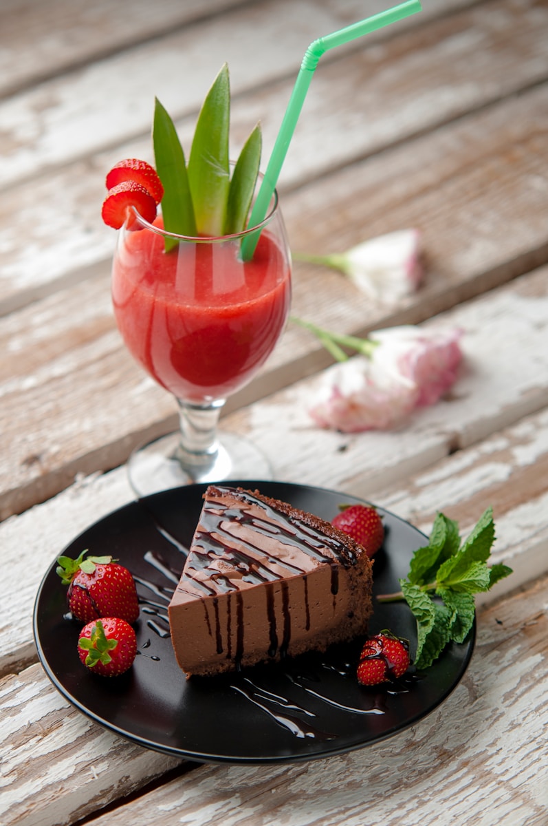 chocolate cake beside strawberries and wine glass